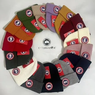 Ribbed knitted beanies in a dozen colours arranged in a circle around a white branded disc