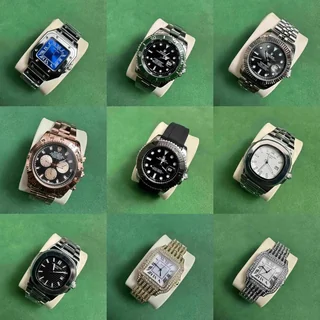 Nine wristwatches with metal and rubber straps, arranged three by three on a green background